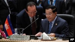 Cambodia's Prime Minister Hun Sen, talks to Cambodia's Foreign Minister Hor Namhong before the plenary session meeting for 26th ASEAN Summit in Kuala Lumpur, Malaysia, on Monday, April 27, 2015. (AP Photo/Joshua Paul)