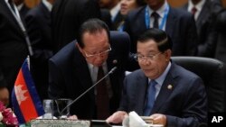 លោក​នាយក​រដ្ឋមន្ត្រី ហ៊ុន សែន សន្ទនា​ជាមួយ​នឹង​លោក​រដ្ឋមន្ត្រីការបរទេស ហោ ណាំហុង មុន​អង្គ​ប្រជុំ​អាស៊ានលើក​ទី២៦នៅ​ទីក្រុងកូឡាឡាំពួរនៃ​ប្រទេស​ម៉ាឡេស៊ី កាល​ពីថ្ងៃច័ន្ទ ទី២៧ ខែ​មេសា ឆ្នាំ២០១៥។ (រូបថត៖ AP/Joshua Paul)