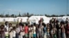 Des enfants font la queue pour recevoir une distribution de nourriture d'un supermarché local dans un centre d'évacuation à Dondo, à environ 35 km au nord de Beira, au Mozambique, le 27 mars 2019. (Photo de Yasuyoshi CHIBA / AFP) 