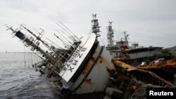 Kapal nelayan yang terbalik akibat Topan Meranti di Kaohsiung, Taiwan (15/9). (Reuters/Tyrone Siu)