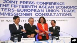 From left; Vietnam's Minister of Industry and Trade Tran Tuan Anh, Secretary of the Philippine Department of Trade and Industry and Chair of the ASEAN Economic Ministers (AEM) Meeting Ramon Lopez, Commissioner for Trade, European Union Cecilia Malmstrom and ASEAN Secretary General Le Luong Minh link arms following a news conference during the ongoing 15th ASEAN Economic Ministers-European Union Trade Consultations, Friday, March 10, 2017, in Pasay city, Philippines. In their statement, the AEM-EU meeting said they "discussed various projects on trade facilitation, Intellectual Property Rights, air transportation and statistics and integration monitoring." (AP Photo/Bullit Marquez)