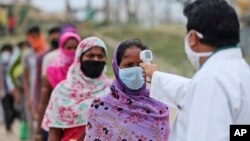 ពលករ​ទេសន្តរប្រវេសន៍​តម្រង់​ជួរ​ឱ្យ​គេ​ពិនិត្យ​មើល​សីតុណ្ហភាព មុន​ចូល​ជិះ​រថភ្លើង​ដើម្បី​ទៅ​ផ្ទះ​របស់​ពួកគេ​នៅ​ក្នុង​ក្រុង Jammu ប្រទេស​ឥណ្ឌា កាលពី​ថ្ងៃទី១១ ខែមិថុនា ឆ្នាំ២០២០។