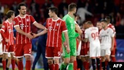 Mats Hummels, à gauche, se serre la main avec Robert Lewandowski après le match conrtrele FC Seville, Espagne, le 3 avril 2018