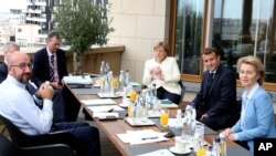 European Council President Charles Michel poses for photographers with German Chancellor Angela Merkel, French President Emmanuel Macron, and European Commission President Ursula von der Leyen, prior to a meeting in Brussels, July 19, 2020.