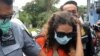 Heather Mack (tengah) digiring oleh petugas imigrasi menuju kantor imigrasi di Jimbaran, Bali, 29 Oktober 2021. (Foto: AFP/Sonny Tumbelaka)