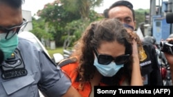 Heather Mack (tengah) digiring oleh petugas imigrasi menuju kantor imigrasi di Jimbaran, Bali, 29 Oktober 2021. (Foto: AFP/Sonny Tumbelaka)