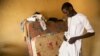 Abdulkadir Abdullahi arranges his school uniform in Maiduguri, Nigeria, October 2016. (C. Oduah/VOA)