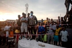 People gather to watch the count of ballots at a polling station after the vote for the presidential and parliamentary election in Jamestown neighborhood, in Accra on Dec. 7, 2020.