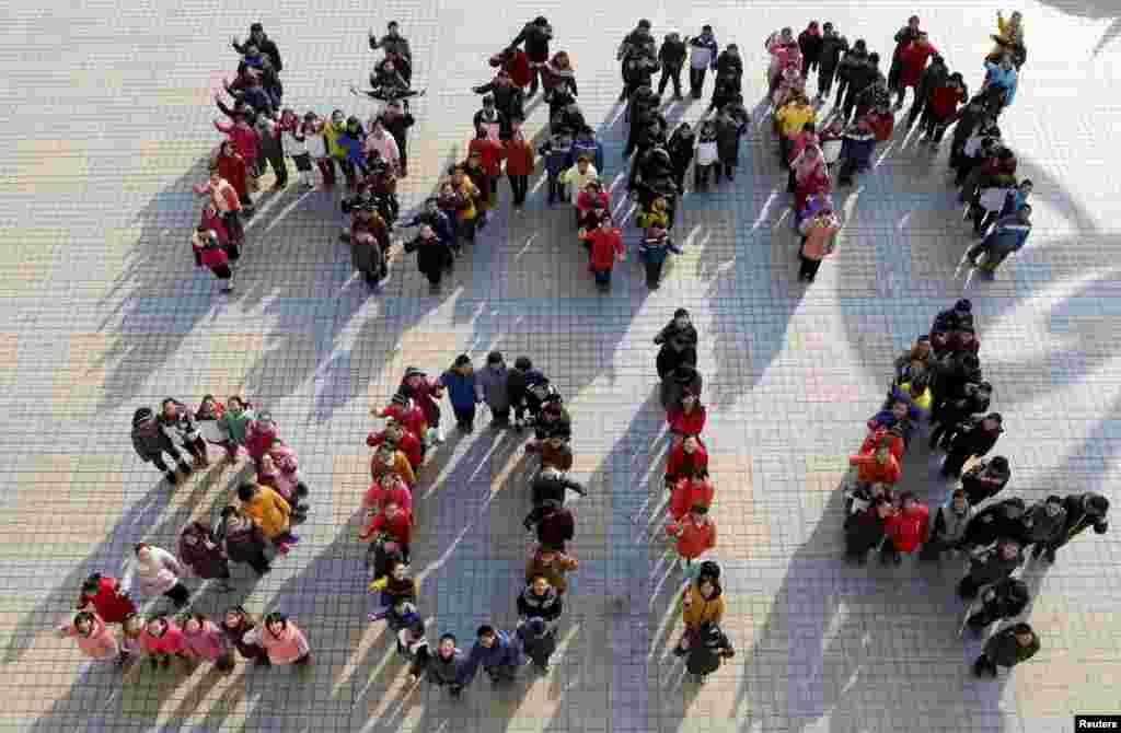 Beberapa pelajar membentuk tulisan &quot;Happy 2014&quot; untuk menyambut tahun baru 2014 di sebuah sekolah di Ma&#39;anshan, provinsi Anhui, China.