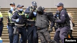 Police officers detain a protester opposing lockdown measures implemented to curb the spread of the coronavirus disease (COVID-19) outside Parliament House in Melbourne, Australia.