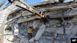 Petugas Pertahanan Sipil Helm Putih (White Helmet) memeriksa lokasi pasca ledakan di Suriah utara, 12 Agustus 2018. (Foto: Syrian Civil Defense White Helmets via AP)