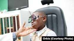 Lemuel Tebuck, now 8 years old, with aligned eyes from strabismus surgery, undergoes a regular check-up at Yaoundé Central Hospital, Yaoundé, Cameeroon, April 2016.