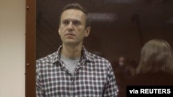 លោក Alexei Navalny មេដឹកនាំ​បក្ស​ប្រឆាំង​រុស្ស៊ី ឈរ​នៅ​ខាង​ក្នុង​បន្ទប់​កញ្ចក់​សម្រាប់​​ជនជាប់ចោទ ក្នុង​អំឡុងពេល​នៃ​សវនាការ​មួយ​ក្នុង​ទីក្រុង​មូស្គូ ប្រទេស​រុស្ស៊ី ថ្ងៃទី២០ ខែកុម្ភៈ ឆ្នាំ២០២១។ 