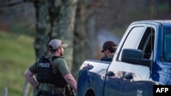 Anggota kepolisian berjaga di jalan menuju kediaman ayah dari Robert Card yang terletak di Bowdoin, yang berjarak sekitar 24 kilometer dari Lewiston, Maine, pada 26 Oktober 2023. (Foto: AFP/Joseph Prezioso)