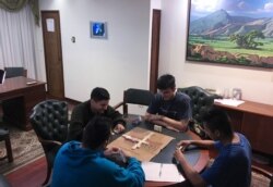 In this Nov. 8, 2019 photo, Venezuelan guardsmen play a game of dominoes inside Panama's Embassy, in Caracas, Venezuela.