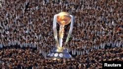 Students give thumbs-up to wish the Indian cricket team luck, as they hold a giant cut-out replica of the Cricket World Cup trophy, at a school in the southern Indian city of Chennai, February 12, 2015. The 2015 Cricket World Cup begins on Feb. 14. REUTER