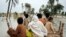 Pakistani villagers make their way through flood waters in Baseera, Pakistan, 24 Aug 2010