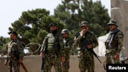 2014年8月5日阿富汗国防军士兵守卫在喀布尔英国办的军事训练学校大门前。