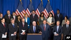 Senator John McCain, center, speaks about immigration reform legislation that would create a path for the nation's 11 million unauthorized immigrants to apply for U.S. citizenship, April 18, 2013, on Capitol Hill in Washington.