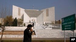 FILE - A Pakistani walks past the Supreme Court building in Islamabad, Pakistan, Feb. 10, 2021.