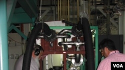 Engineers check the Green Machine, which converts waste heat into electricity, at Southern Methodist University in Dallas, Texas