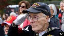 FILE - World War II Navy veteran Donald E. Hanson, 94, of Kent, Wash., salutes during a Veterans Day ceremony at Tahoma National Cemetery, Friday, Nov. 11, 2016, in Kent, Wash. (AP Photo/Ted S. Warren)