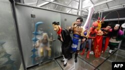 Aktor-aktor 'cosplay' berfoto dalam toilet kaca umum untuk menandai Hari Toilet Dunia di Changsha, provinsi Hunan (19/11). 