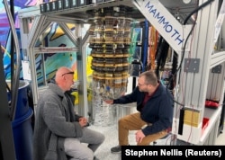 Google Quantum AI's Hartmut Neven (L) and Anthony Megrant (R) examine a cryostat refrigerator for cooling quantum computing chips at Google's Quantum AI lab in Santa Barbara, California, U.S. November 25, 2024. (REUTERS/Stephen Nellis)