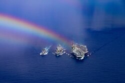 일본 해상자위대 소속 이카주치 구축함(왼쪽부터)과 미 해군 존에릭슨 해상급유함, 로널드레이건 항공모함이 지난달 16일 필리핀해에서 기동훈련을 했다.