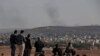 2014年10月15日，民众聚集在土叙边界附近的苏鲁克郊外山头，观看叙利亚库尔德人和伊斯兰国极端分子在叙利亚的科巴尼交战。
