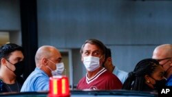 Presiden Brazil Jair Bolsonaro (tengah) meninggalkan Rumah Sakit Vila Nova Star di Sao Paulo, Brazil, pada 5 Januari 2022. Bolsonaro menjalani perawatan untuk sakit yang ia derita di bagian perut. (Foto: AP/Marcelo Chello)