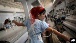 북한 김정숙평양방직공장에서 한 여성 노동자가 실을 뽑고 있다. (자료사진)