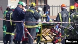 A man raises his hand as rescue workers carry him to an ambulance after he survived 116 hours following a deadly building collapse in George, South Africa, on May 11, 2024. (Garden Route District Municipality via Reuters)