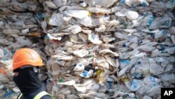 FILE - A container is filled with plastic waste from Australia, in Port Klang, Malaysia, May 28, 2019.