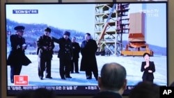 FILE - A man watches a TV screen showing a file image of the North Korean leader Kim Jong Un at his county long-range rocket launch site during a news program at the Seoul Railway Station in Seoul, South Korea, Monday, Dec. 9, 2019. 