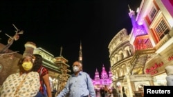 People wear protective masks, following an outbreak of coronavirus, as they walk at Global Village in Dubai, United Arab Emirates, March 10, 2020.