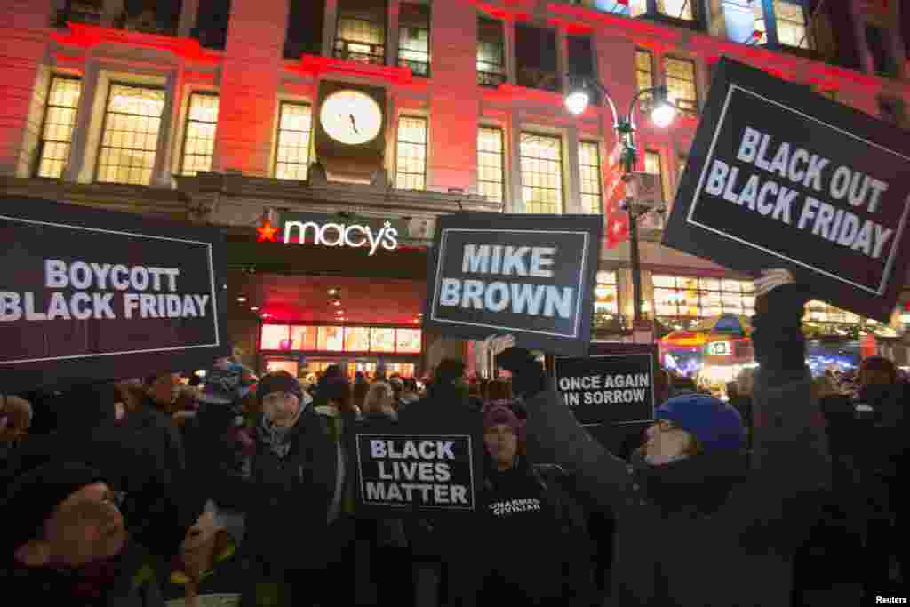 Protesters hold signs aloft outside Macy&#39;s before the kick off of Black Friday sales in New York, November 27, 2014.