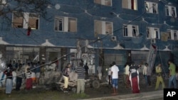 Somali security forces and civilians gather outside the Weheliye hotel after it was stormed by militants in Mogadishu, Somalia, July 10, 2015. 