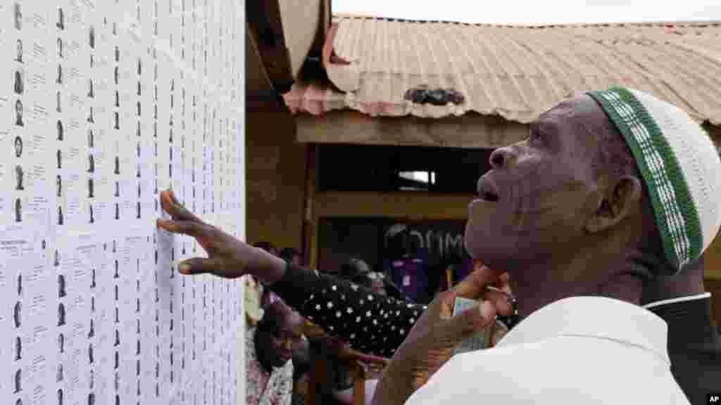 A man looks for his name on a list before he registers to vote, prior to casting his ballot later in the day, in Lagos, Nigeria, March 28, 2015.
