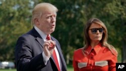 President Donald Trump, accompanied by first lady Melania Trump, stops to answers reporters' questions, on the South Lawn of the White House in Washington, Sept. 10, 2017.
