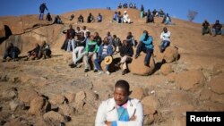 Miners gather at a hill known as the "Hill of Horror" ahead of the one-year anniversary commemorations to mark the killings of 34 striking platinum miners shot dead by police outside the Lonmin's Marikana platinum mine in Rustenburg, South Africa, Aug. 16