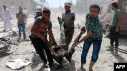 ក្រុម​ការងារ​ជួយ​សង្រ្គោះ និង​ជន​ស៊ីវិល​ជម្លៀស​បុរស​ម្នាក់​នៅ​ក្នុង​ស្រុក Maadi បន្ទាប់​ពី​មាន​យន្តហោះ​ទម្លាក់​គ្រាប់​បែក​ធុង​ កាលពី​ថ្ងៃទី២៧ ខែសីហា ឆ្នាំ២០១៦។