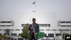 A Pakistani police commando stands guard at the parliament in Islamabad, Pakistan on, March 20, 2012. A special panel met Tuesday to discuss a review of tense relations with the United States. 