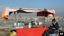 FILE - In this Jan. 28, 2019 file photo, an Afghan street vendor waits for customers on the outskirts of Kabul, Afghanistan. In a Thursday, March 28, 2019 report the Special Inspector General for Afghan Reconstruction, a U.S. watchdog, said that…