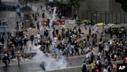 Polisi anti huru-hara menembakkan gas air mata untuk membubarkan pendemo di luar gedung DPR Hong Kong, 12 Juni 2019. 