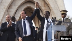 Le président François Hollande de France (2e G) joint les mains avec le président intérimaire Dioncounda Traoré du Mali à la place de l'Indépendance à Bamako, au Mali 2 février, 2013.