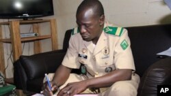 Mali's military junta leader, Captain Amadou Sanogo signs documents as the junta and the West African bloc ECOWAS announced a deal that includes the lifting of sanctions and an amnesty for those involved in last (file photo),