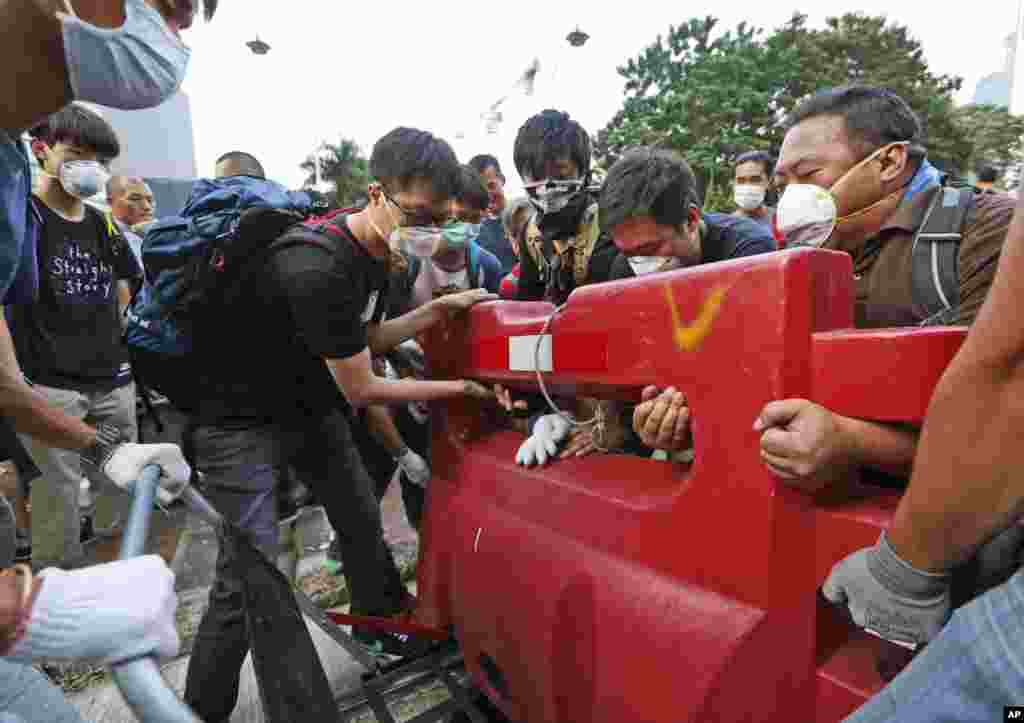 Pro-democracy demonstrators build a barricade on the main road in the occupied areas outside the government headquarters in Hong Kong&#39;s Admiralty district, Oct. 13, 2014. 