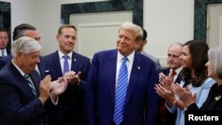 도널드 트럼프 전 미국 대통령(가운데)이 13일 의사당에서 공화당 상원의원들의 박수를 받고 있다. 