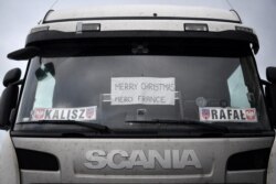 A sign in the window of a truck driver's cab reads "Merry Christmas, Merci France", as the heavy goods vehicle sits in a queue trying to enter the Port of Dover, in Kent, south east England, Dec. 23, 2020.